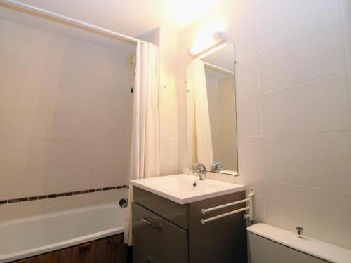 une salle de bain avec un lavabo, un miroir et une baignoire dans l'établissement Saint Cyprien - T3 lumineux avec plage, piscine collective et parking privé - FR-1-309-356, à Saint-Cyprien