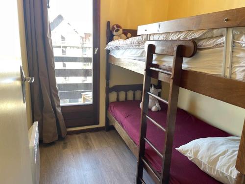 une chambre avec deux lits superposés et une fenêtre dans l'établissement Appartement cosy à Risoul 1850, 3 pièces, 6 pers., pied des pistes, proche commodités et luge - FR-1-330-560, à Risoul