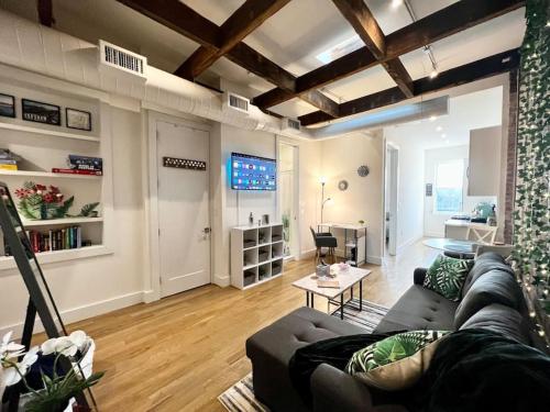 a living room with a couch and a tv in it at Chic Industrial Home In City Center in Hoboken