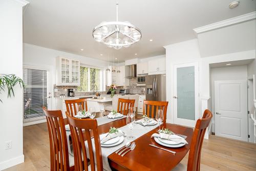 a kitchen and dining room with a table and chairs at Comfortable and Modern Rowhouse Perfect for BC Escapade, air conditioned in Langley