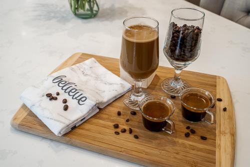 a wooden tray with two glasses of coffee and a bag of coffee beans at Comfortable and Modern Rowhouse Perfect for BC Escapade, air conditioned in Langley
