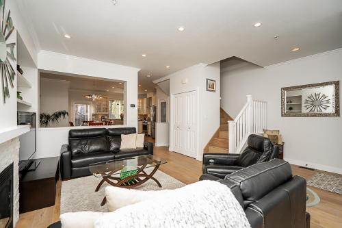 a living room with black leather furniture and a fireplace at Comfortable and Modern Rowhouse Perfect for BC Escapade, air conditioned in Langley