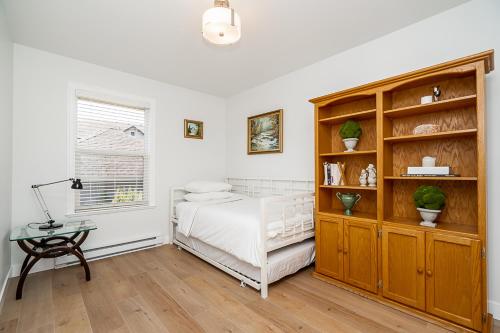 a bedroom with a bed and a book shelf at Comfortable and Modern Rowhouse Perfect for BC Escapade, air conditioned in Langley