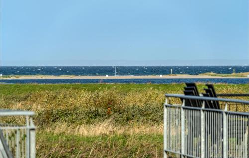 a group of chairs sitting on a porch looking at the water at Cozy Apartment In Bogense With Sauna in Bogense