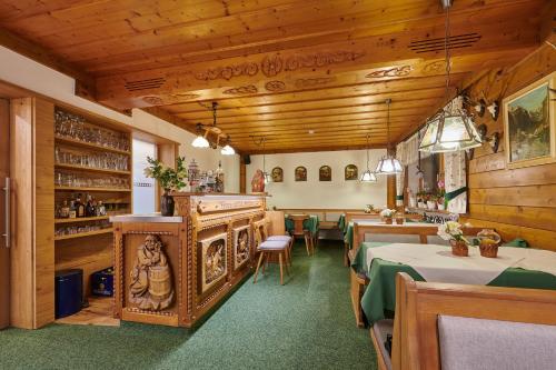 un restaurant avec des tables et des chaises et des plafonds en bois dans l'établissement Gästehaus Sonnenbichl, à Berchtesgaden