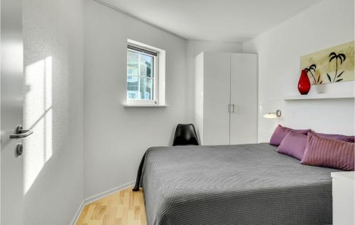 Un dormitorio con una cama con almohadas moradas y una ventana en Cozy Apartment In Bogense With Sauna en Bogense