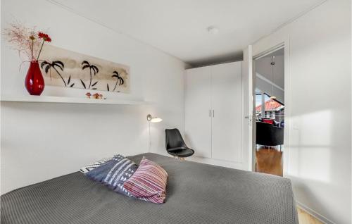 a bedroom with a bed and a vase on the wall at Cozy Apartment In Bogense With Sauna in Bogense
