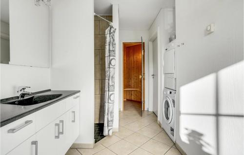 a white kitchen with a sink and a washing machine at Cozy Apartment In Bogense With Sauna in Bogense