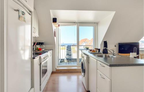 a kitchen with white cabinets and a large window at Stunning Apartment In Lemvig With Wifi in Lemvig