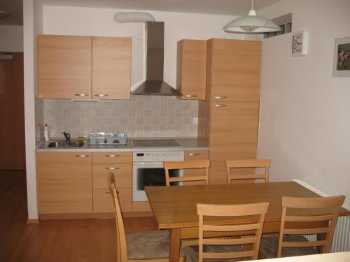 een keuken met een houten tafel en een fornuis top oven bij Apartma Jeglic in Bohinj