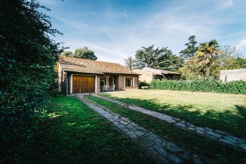 a house with a grass yard next to a building at LA PAZ in Sierra de la Ventana