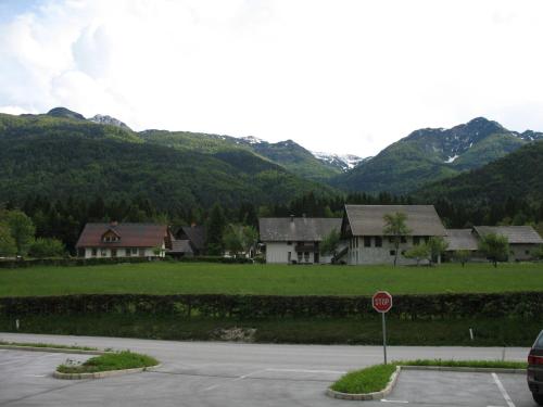 a stop sign in front of some houses with mountains at Apartma Jeglic in Bohinj