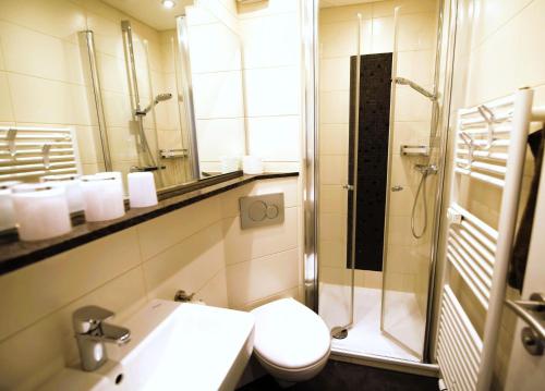 ein Bad mit einer Dusche, einem WC und einem Waschbecken in der Unterkunft Lord Nelson 214 in Döse