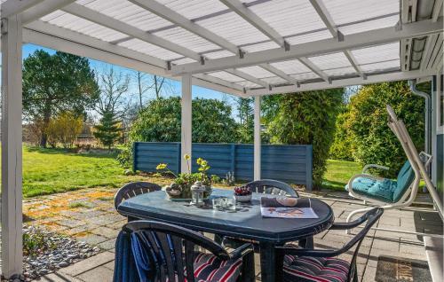 a patio with a table and chairs under a white pergola at Gorgeous Home In Gilleleje in Gilleleje