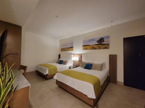 a hotel room with two beds and a tv at Villa con jacuzzi privado en Descanso in Primo Tapia