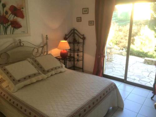 - une chambre avec un lit, une fenêtre et une lampe dans l'établissement Maison d'hôtes Escale d'Azur, à Gattières