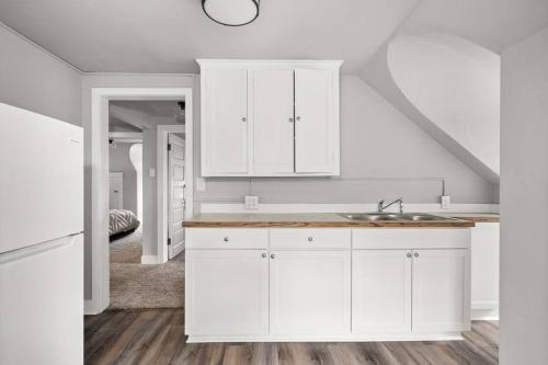 a kitchen with white cabinets and a sink at Entire 2nd and 3rd level of Spacious Historic Home in Spokane