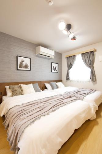 two large white beds in a bedroom with a window at メイスン倶楽部 501 in Asato