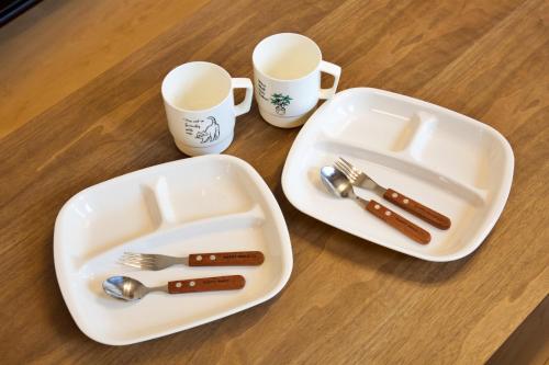 a table with two plates and utensils and two cups at メイスン倶楽部 501 in Asato
