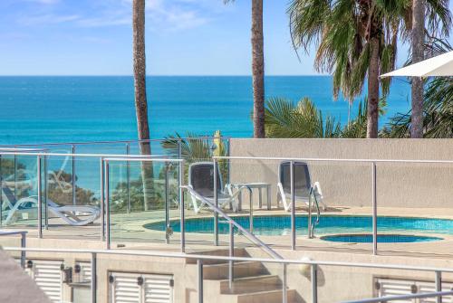 a swimming pool with a view of the ocean at Noosa Crest Resort in Noosa Heads
