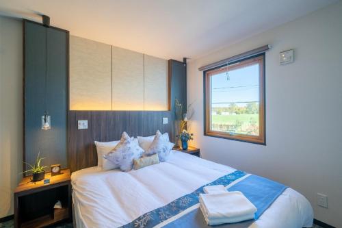 een slaapkamer met een groot bed en een raam bij HOUSE HOTEL MASHU - Vacation STAY 88249 in Sapporo