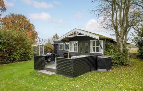 a small black house with a deck in the grass at Pet Friendly Home In Nexø With Wifi in Neksø