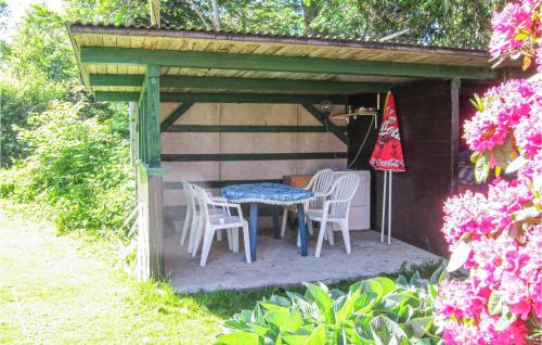 a patio with a table and chairs under a pergola at Pet Friendly Home In Nexø With Wifi in Neksø