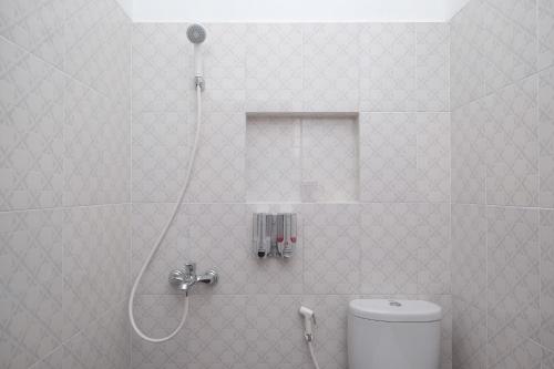 y baño con ducha y aseo. en RedDoorz Syariah near Kampus UNSOED Purwokerto, en Banyumas