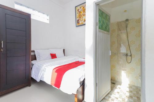 a white bedroom with a bed and a bathroom at RedDoorz Syariah near Universitas Jember in Jember