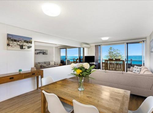 a living room with a vase of flowers on a wooden table at Park Towers-Goodwin Towers Holiday Units in Gold Coast