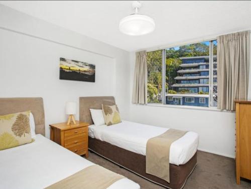 a hotel room with two beds and a window at Park Towers-Goodwin Towers Holiday Units in Gold Coast