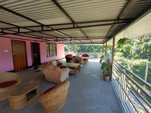 patio con sillas y mesas y balcón en Wind Valley Homestay, en Pelling
