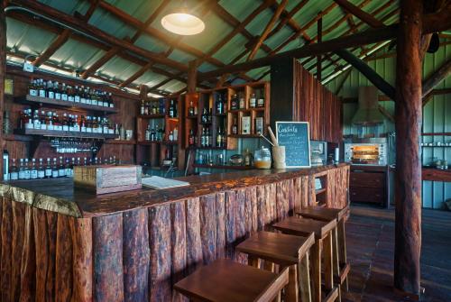a bar with wooden tables and wooden chairs at Manicou River Resort in Portsmouth