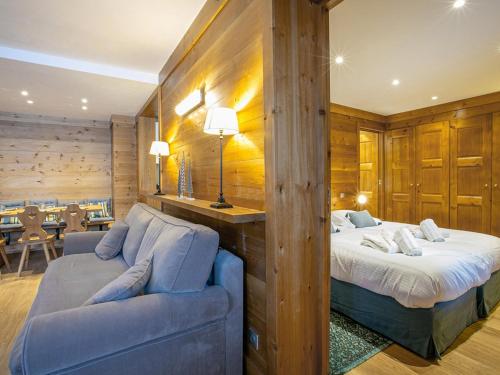 une chambre avec un lit, un canapé et une table dans l'établissement Appartement skis aux pieds avec balcon, cheminée et parking - Méribel - FR-1-613-3, à Méribel