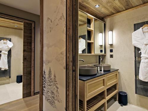 a bathroom with a sink and a mirror at Appartement chic Méribel - skis aux pieds, cheminée & parking - FR-1-613-40 in Méribel
