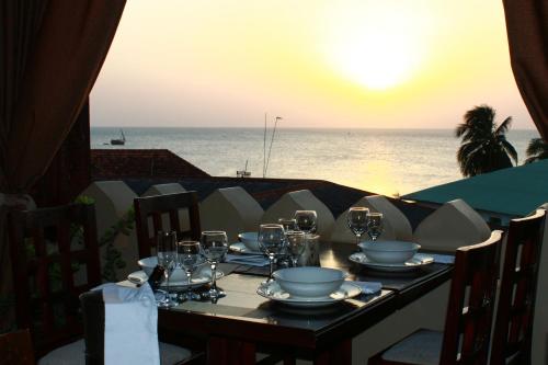 a table with glasses and plates on top of the ocean at Al Johari Hotel & Spa in Zanzibar City