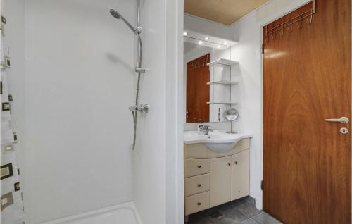 een badkamer met een wastafel en een houten deur bij Stunning Home In Mern With Kitchen in Mern
