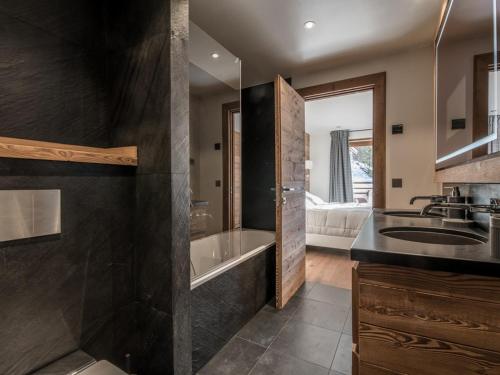 une salle de bain avec une baignoire et un lavabo et une baignoire dans l'établissement Appartement de Luxe aux Allues : 5 Ch, Skis aux Pieds, Terrasses, Services Premium - FR-1-613-18, à Méribel