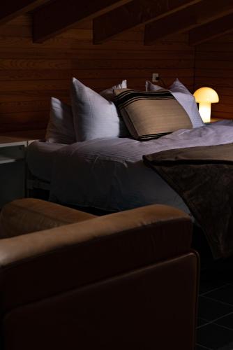a bedroom with two beds with pillows and a lamp at VILLA HUNDERT Boutique Mountainscape in Engelberg