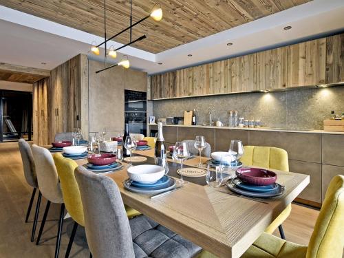 une salle à manger avec une table et des chaises en bois dans l'établissement Appartement de luxe, skis aux pieds, Méribel - FR-1-613-39, à Méribel