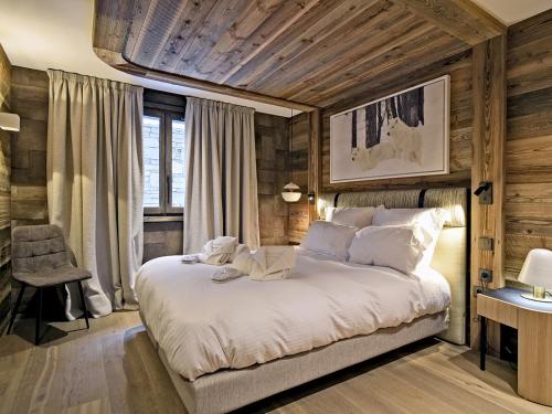a bedroom with a large bed with wooden walls at Appartement de luxe, skis aux pieds, Méribel - FR-1-613-39 in Méribel