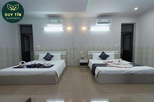 two beds in a hotel room with towels on them at Xuân Hải Complex-Hotel in Song Cau