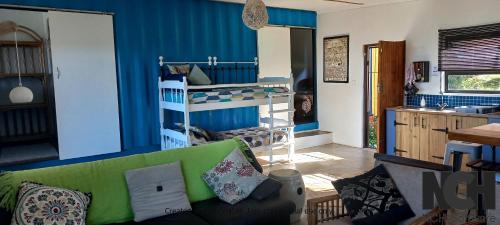 sala de estar con sofá verde y pared azul en Blue Space Beach house en Port Shepstone