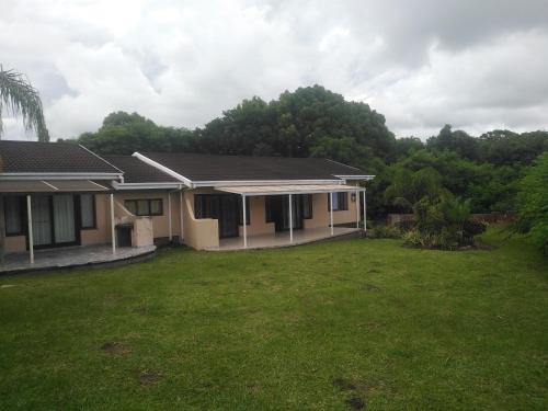 ein Haus mit einem Rasenplatz davor in der Unterkunft The Royal Holiday Home in Port Shepstone