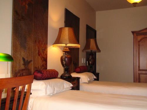 a bedroom with two beds with lamps on them at Villa Lugano Guesthouse in Johannesburg