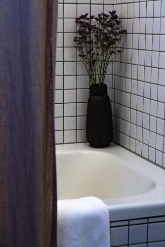 a vase of flowers sitting on top of a bath tub at VILLA HUNDERT Boutique Mountainscape in Engelberg