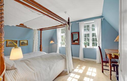 - une chambre avec un lit à baldaquin et des murs bleus dans l'établissement 8 Bedroom Beautiful Home In Kvrndrup, à Kværndrup