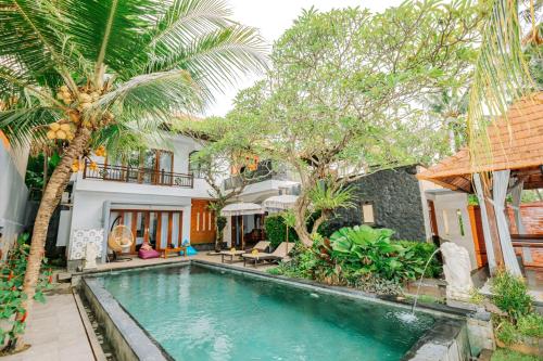 a pool in front of a house with palm trees at Kayangan Villas Saba in Keramas