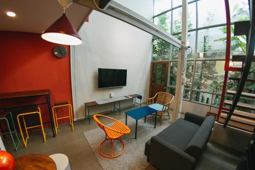 a living room with a couch and chairs and a tv at HomeHomeBangsaen in Ban Bang Saen (1)