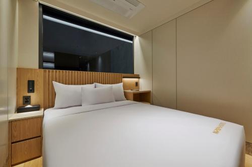 a bedroom with a large white bed and a window at N285 Hotel Insadong in Seoul